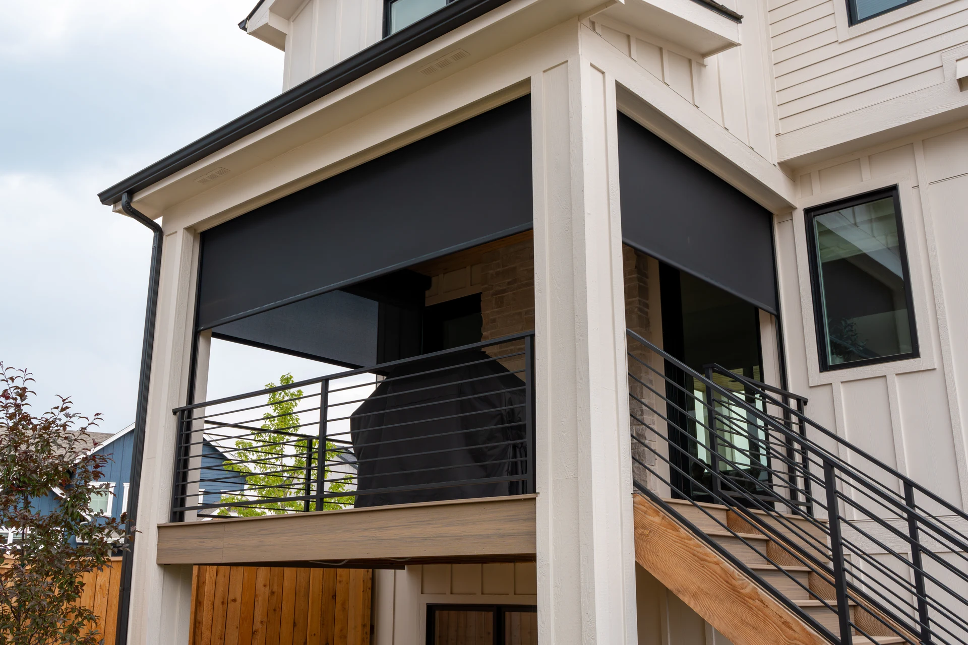Insolroll outdoor shades partially lowered around a covered residential deck